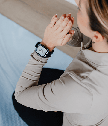 Woman wearing a smartwatch while sitting, shown using a digital cough-monitoring device